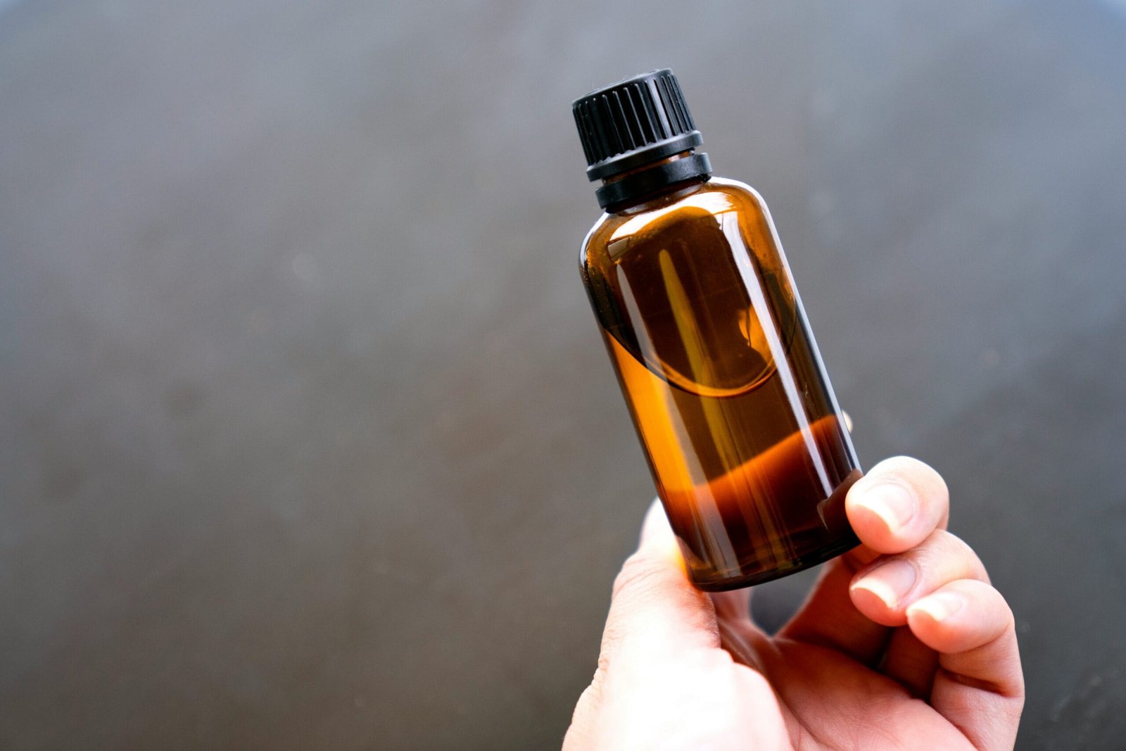 a person holding a bottle of essential oils